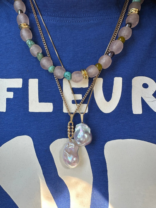 Necklace with beads and chain on a blue background with white text