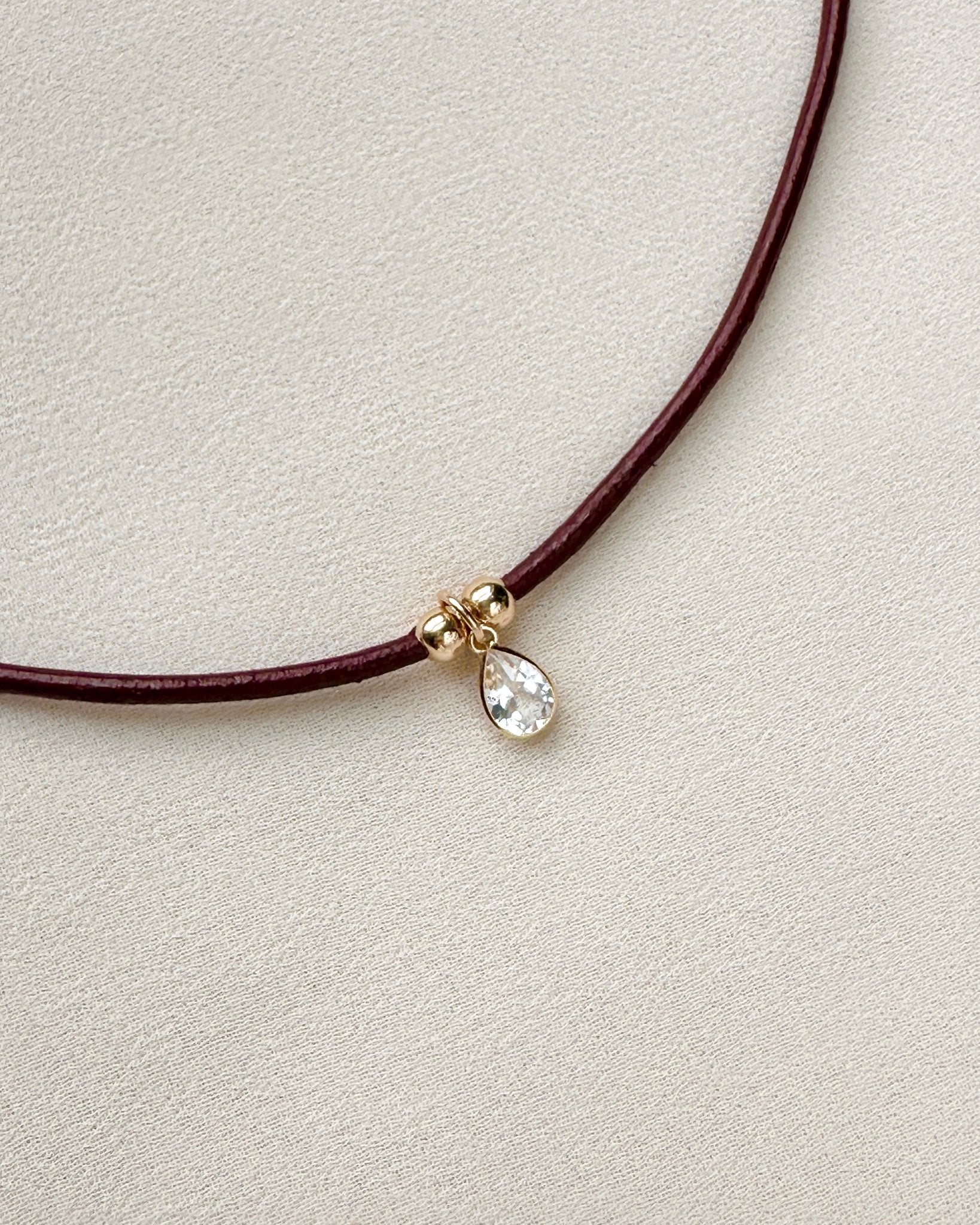 burgundy leather cord necklace with white topaz pendant and gold-filled beads — close-up