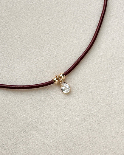burgundy leather cord necklace with white topaz pendant and gold-filled beads — close-up