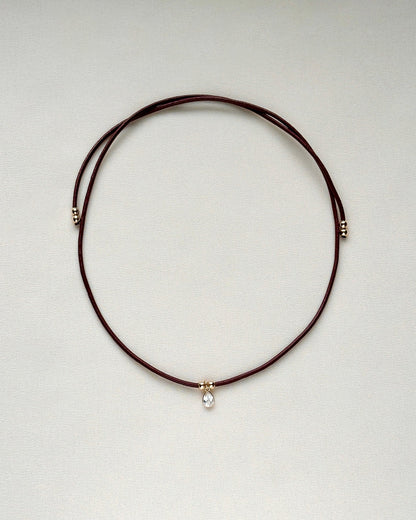 full view of burgundy leather cord necklace with white topaz and gold-filled accents