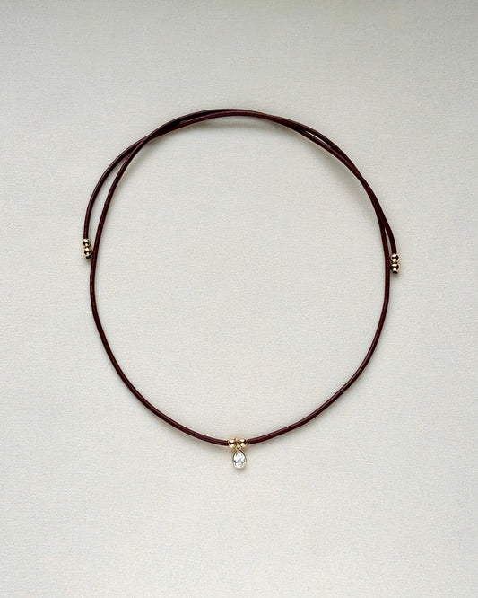 full view of burgundy leather cord necklace with white topaz and gold-filled accents