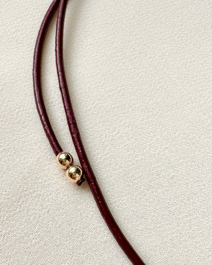 white topaz teardrop charm on burgundy leather cord — product detail