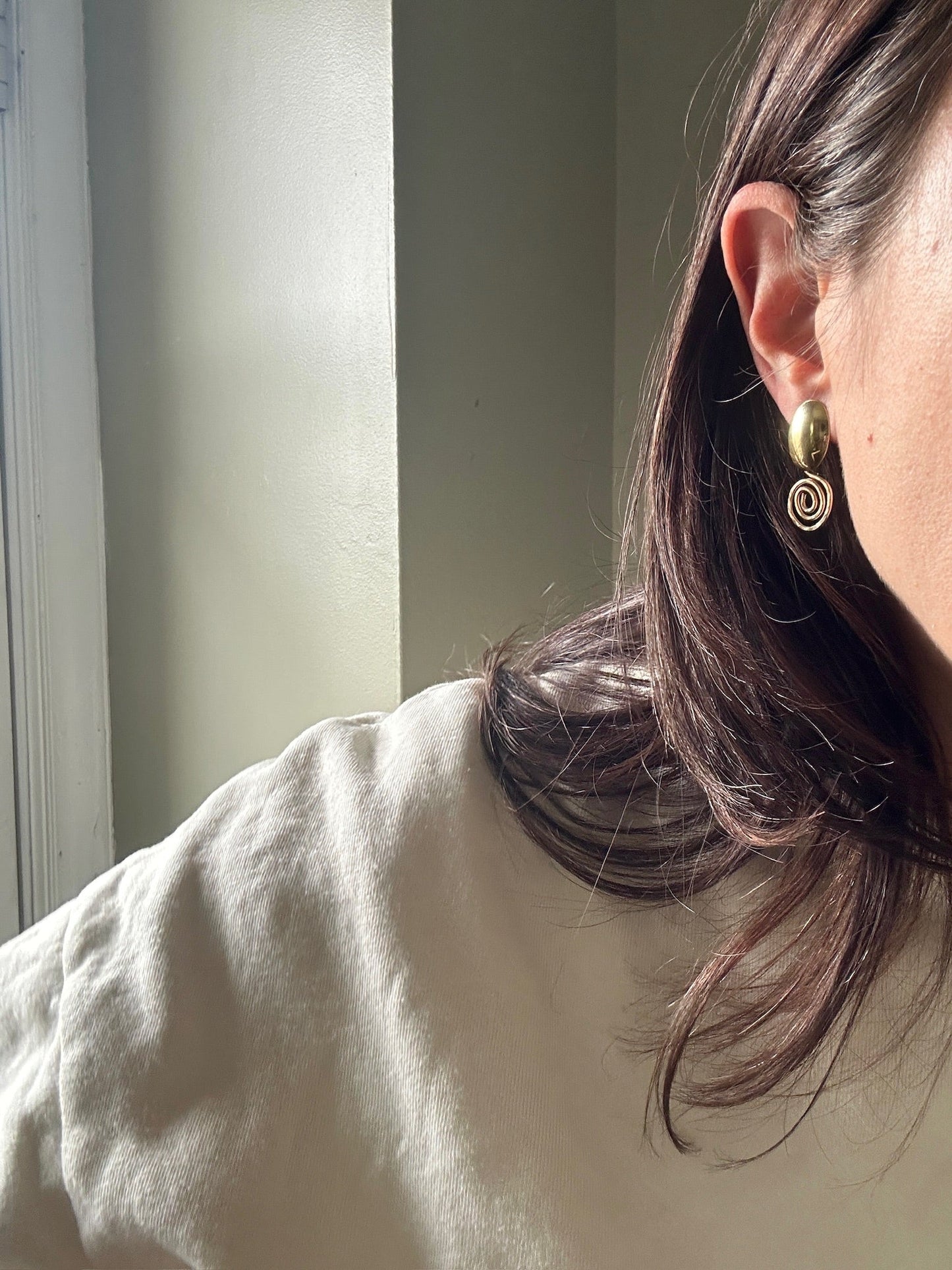 Gold filled spiral earrings worn on ear by Standing O