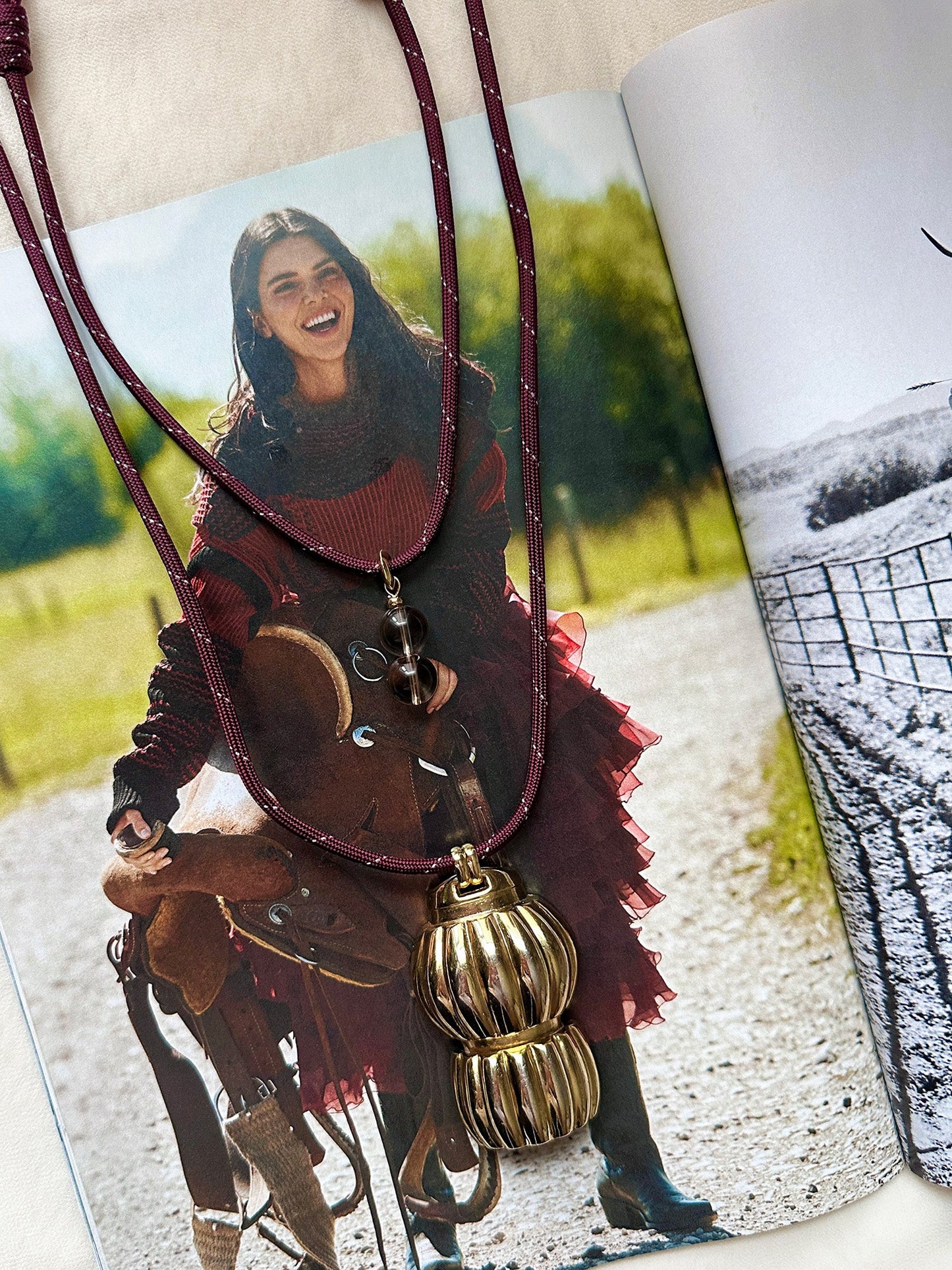 Paracord necklaces with gold pendants on a magazine page