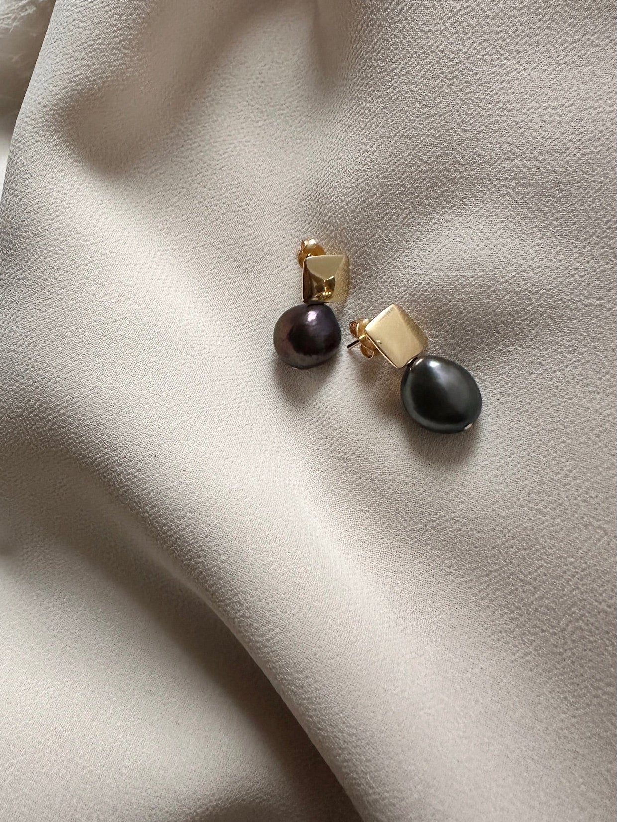 Dark pearl stud earrings with gold square detail