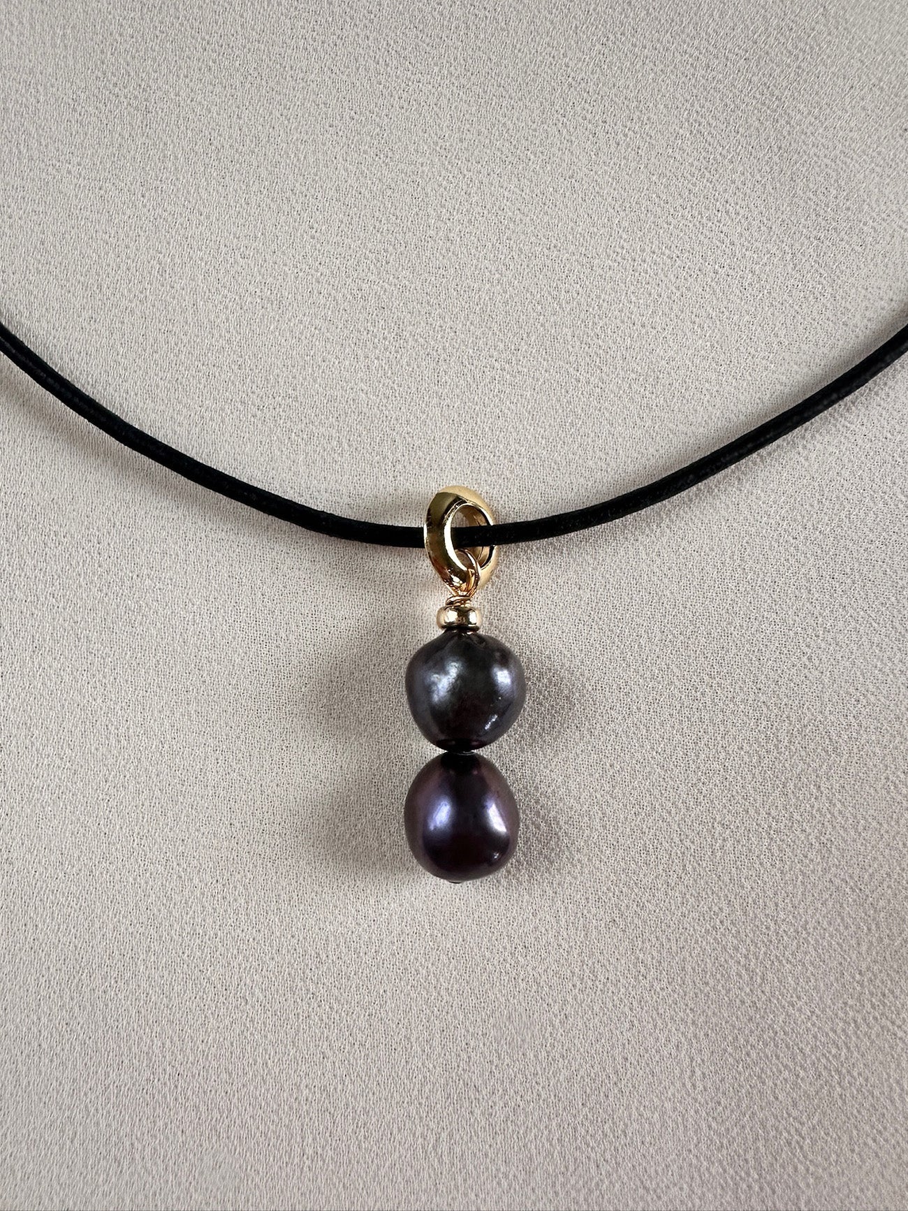 Dark freshwater pearls on gold-toned loop detail and leather cord